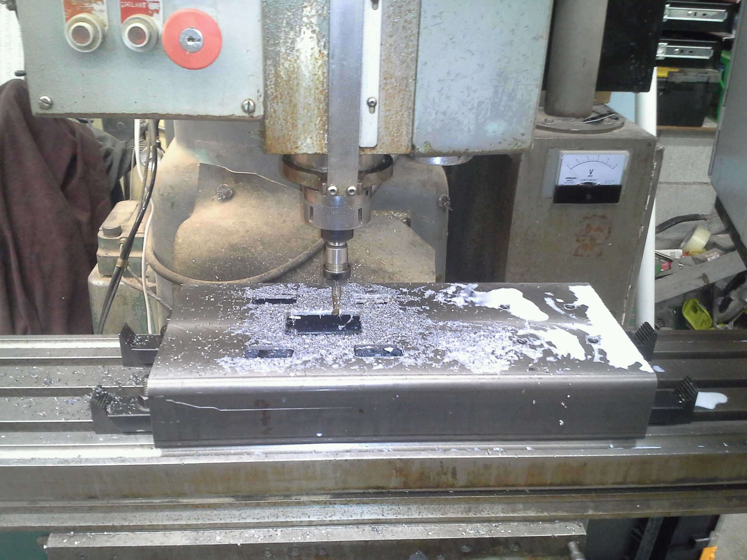 mostly cut fore motor frame face, still on the milling machine, littered with coolant and chip